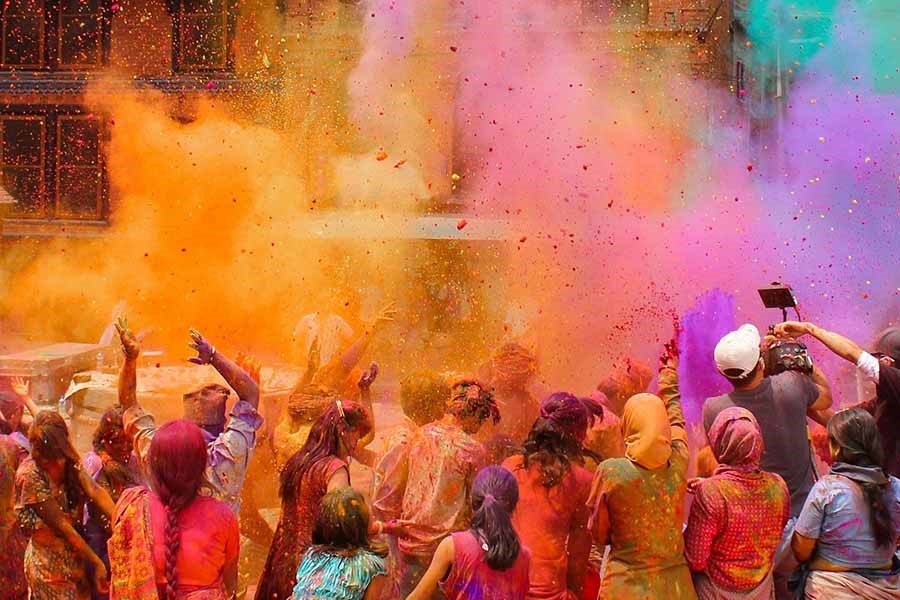 جشن هولی هند با رنگ‌ها، موسیقی و شادی در خیابان‌ها.