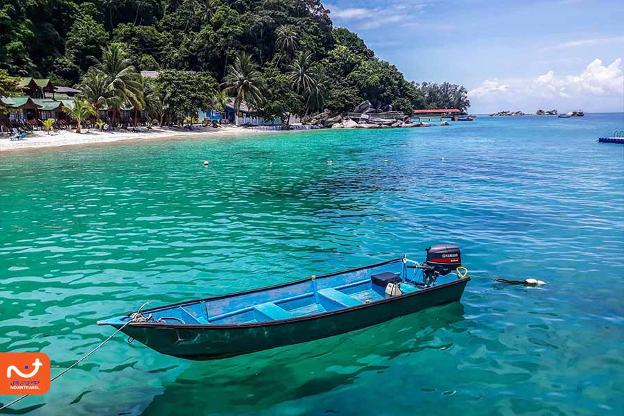 نمایی از یک قایق در آبهای شفاف جزایر پرهنتیان مالزی، با سواحل زیبا.