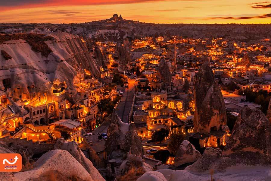 "نمایی از روستای گورمه در کاپادوکیا با خانه‌های صخره‌ای و دودکش‌های پری‌ها در پس‌زمینه"