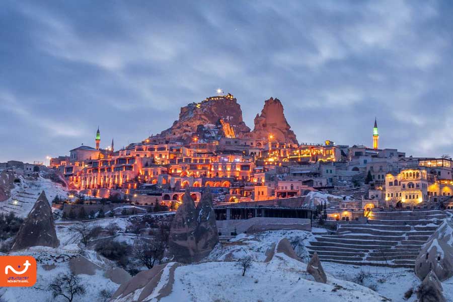 "تصویری از قلعه اوچ‌حصار در کاپادوکیا با چشم‌انداز وسیع به دره‌ها و خانه‌های سنگی اطراف"